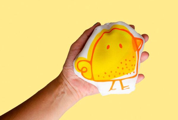 a hand holding a yellow bird